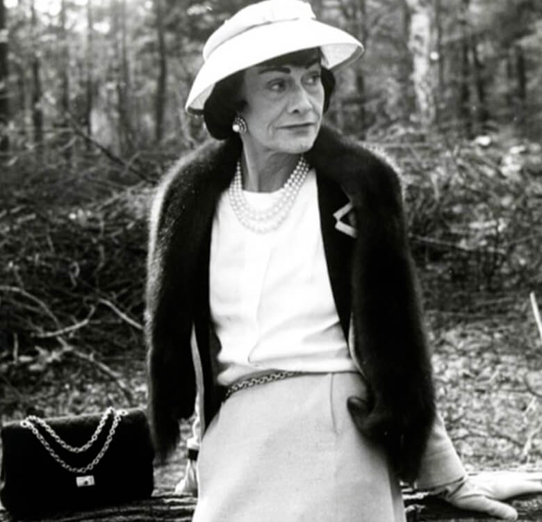 Coco Chanel idosa vestindo chapéu