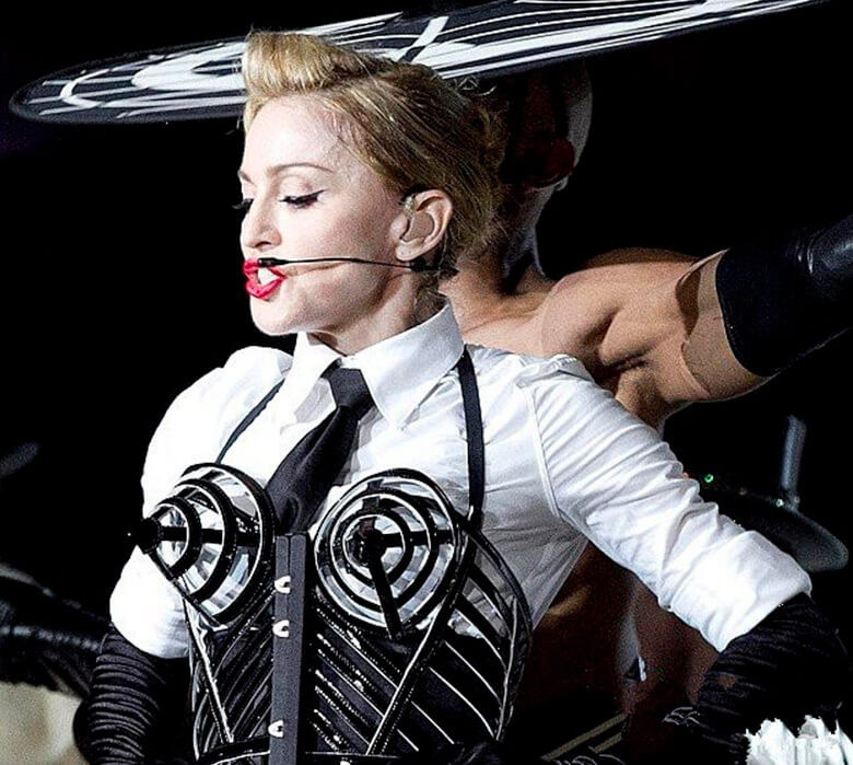 Madonna com sutiã de arame por cima da blusa