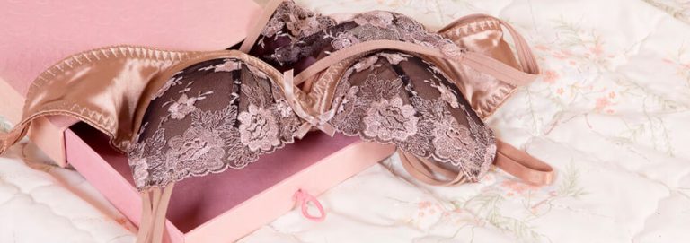 Lingerie rosa dentro de uma caixa em cima da cama