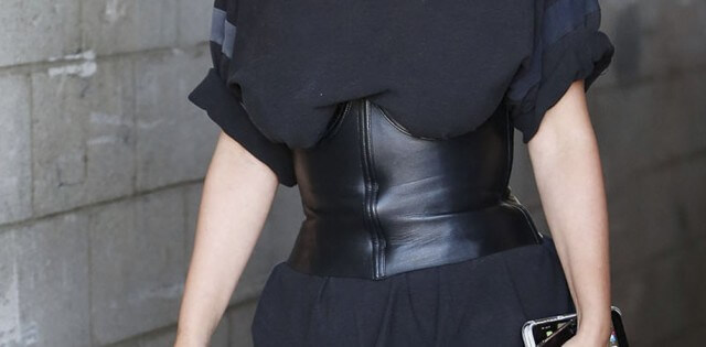 Mulher usando corset por cima da blusa