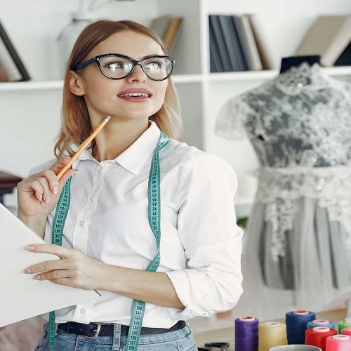 Estilista preenchendo fichas técnicas de confecção