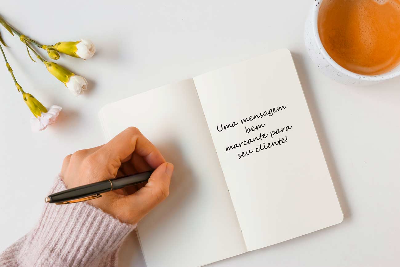 Uma mesa branca com uma espécie de caderno, escrevendo um bilhete para o cliente, usando a psicologia de vendas para demonstrar afeto e atenção.
