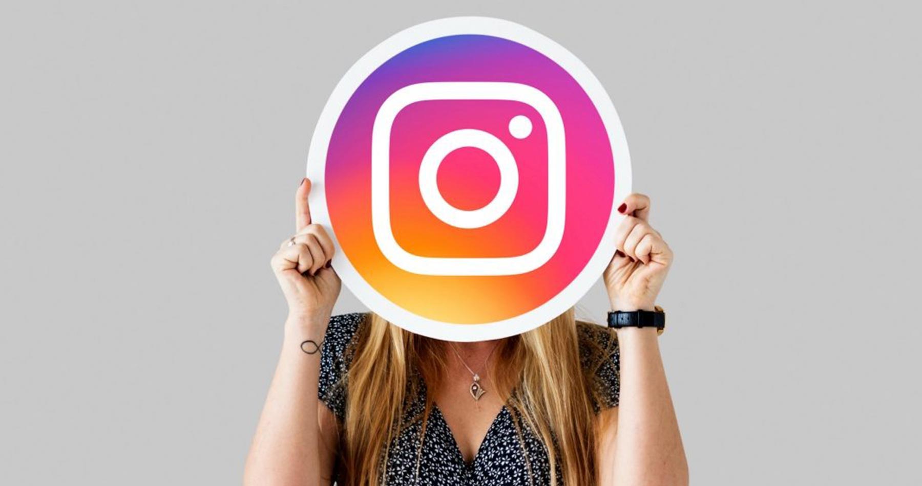 mulher segurando placa com o símbolo do Instagram, em referencia ao conteúdo de como vender pelo Instagram