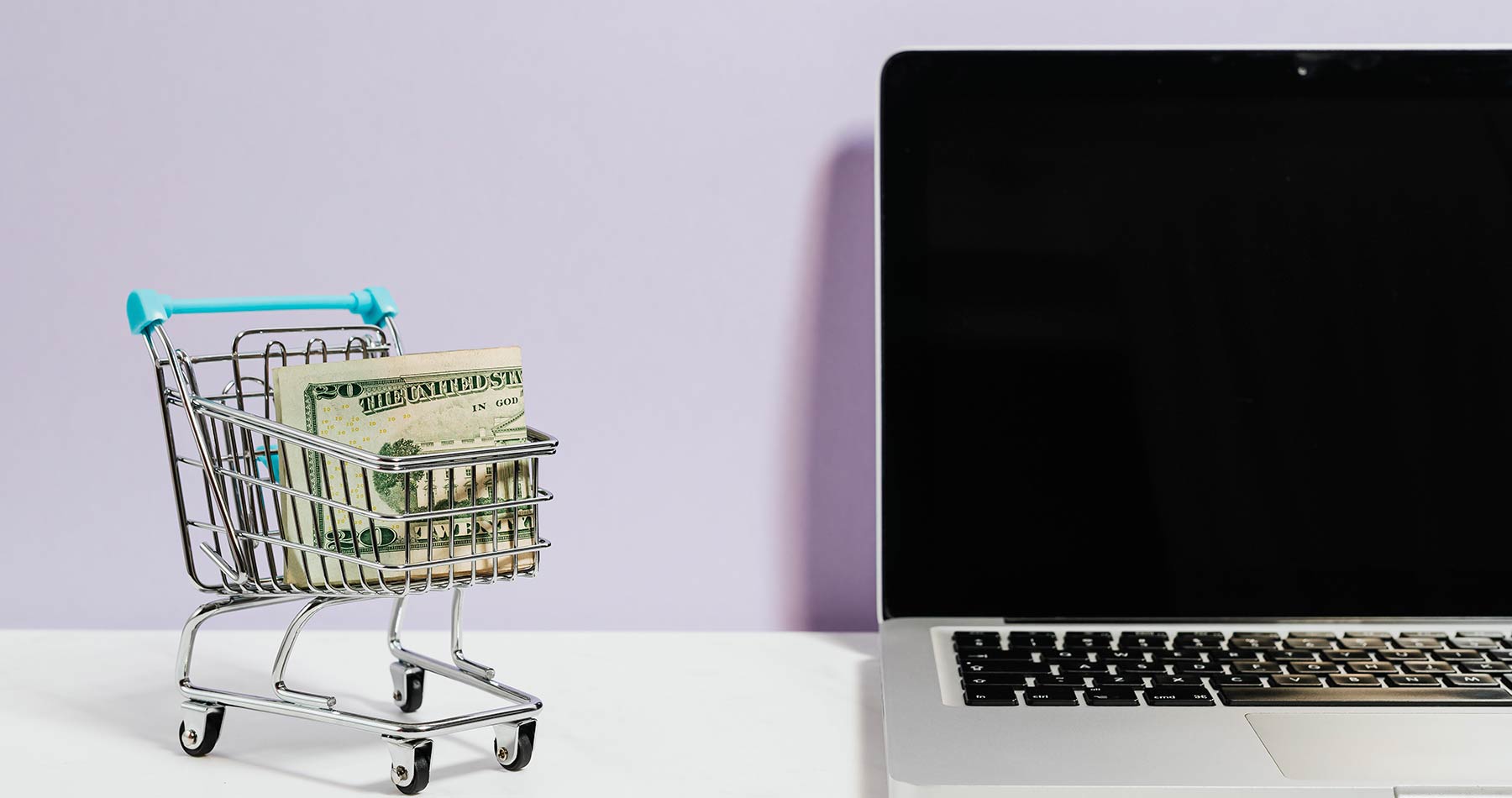 imagem mostrando um notebook e um carrinho de mercado em miniatura com dinheiro dentro, representando o conteúdo se como aumentar as vendas online
