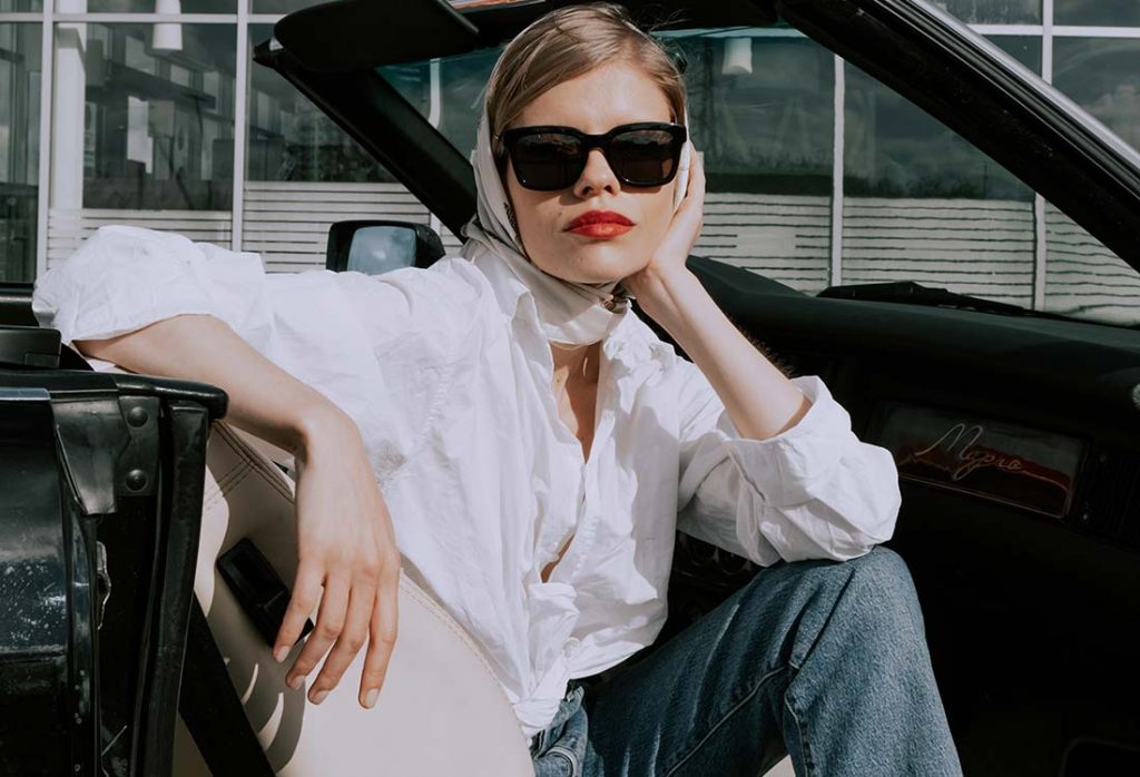 Jovem bonita com lenço na cabeça usando roupas no estilo old money