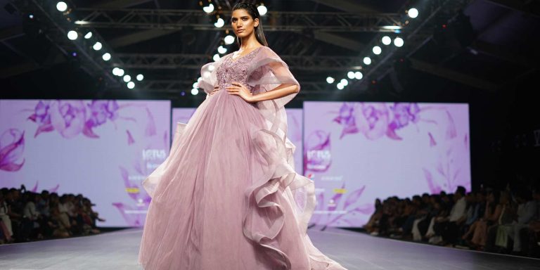 Modelo desfilando com vestido exuberante mostrando as diferenças entre moda conceitual e moda comercial