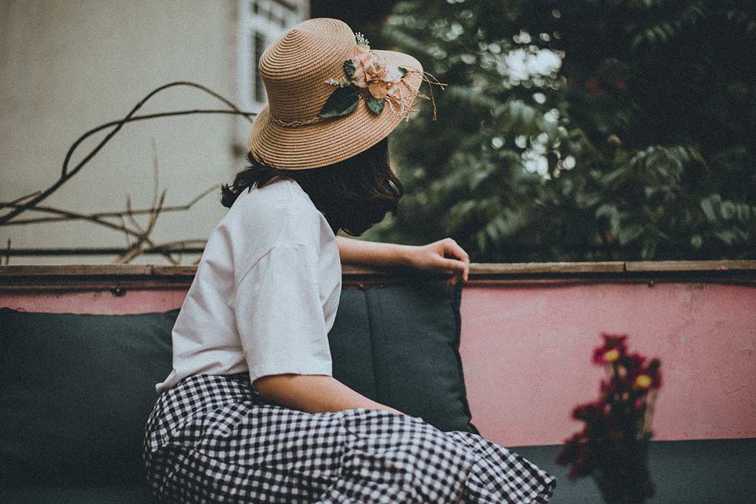 jovem de chapéu olhando a paisagem vestida no estilo vintage