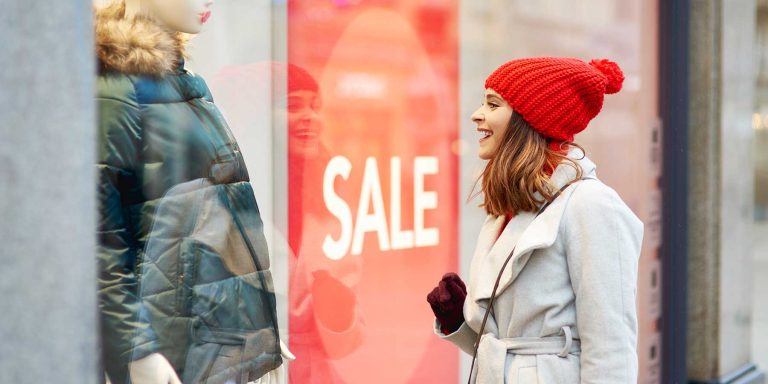 Mulher jovem e bonita admirando vitrine dentro do visual merchandising