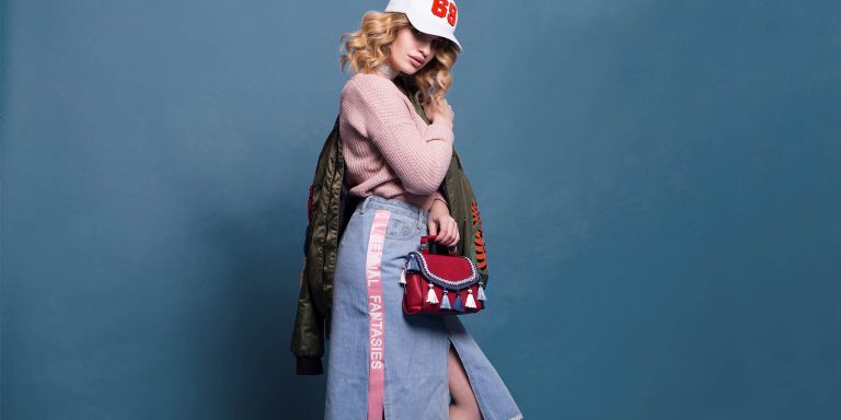 Jovem de saia midi jeans e boné fazendo referência moda cilcica