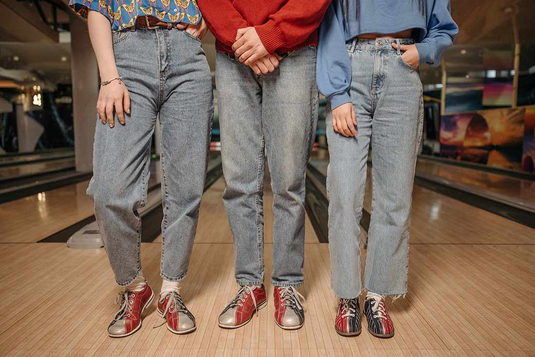 Três amigos com calça jeans da moda cíclica