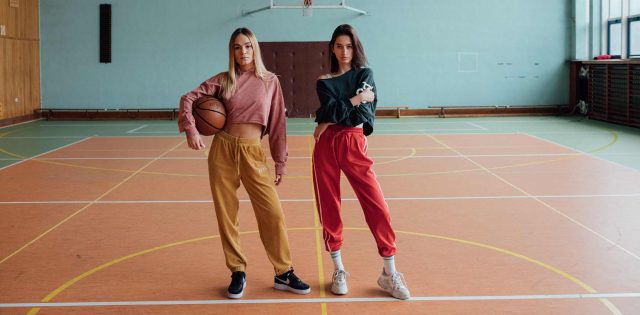 Duas jovens esportistas na quadra de basquete vestindo roupas no estilo activewear