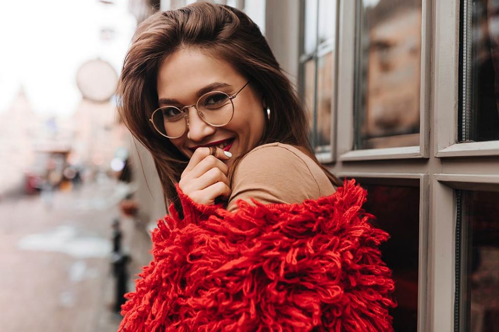 Mulher de óculos vestindo plumas uma tendência da a moda outono/inverno 2022