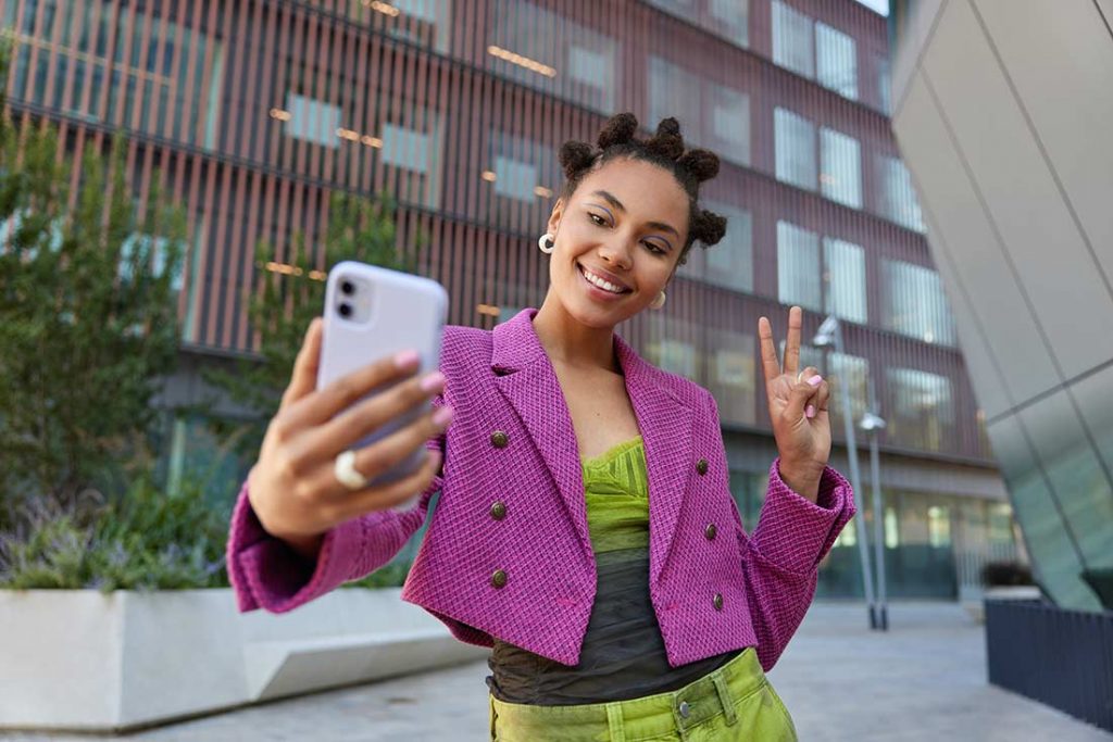 Jovem fazendo selfie com look de cores combinando com o circulo cromático