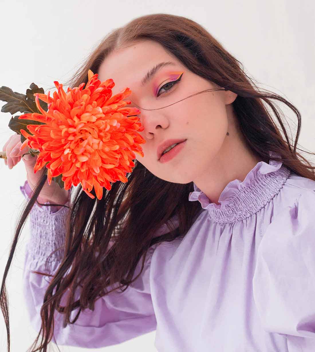Menina com uma flor no rosto usando uma blusa lilás como aplicar o lastex