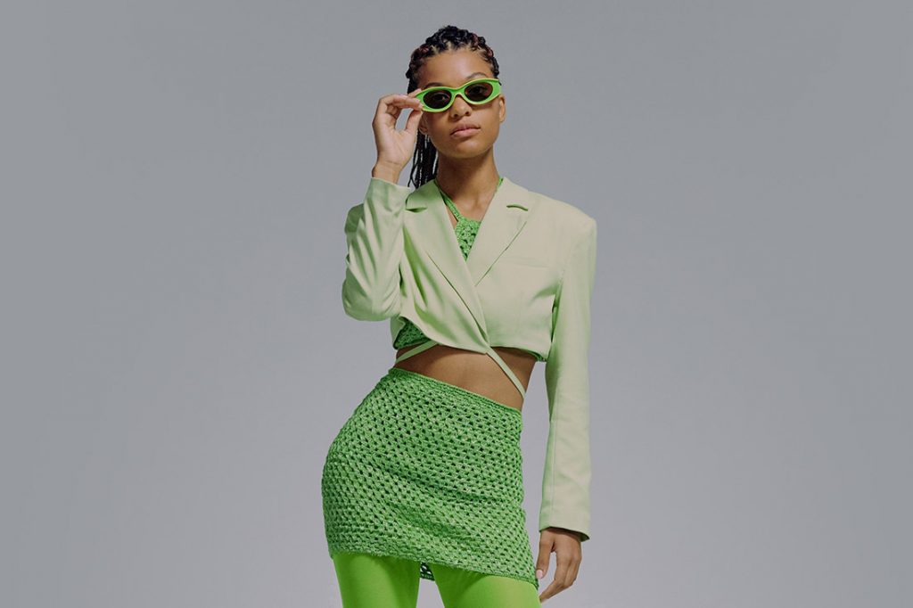 Jovem morena com look em tons de verde formando uma combinação monocromática do circulo