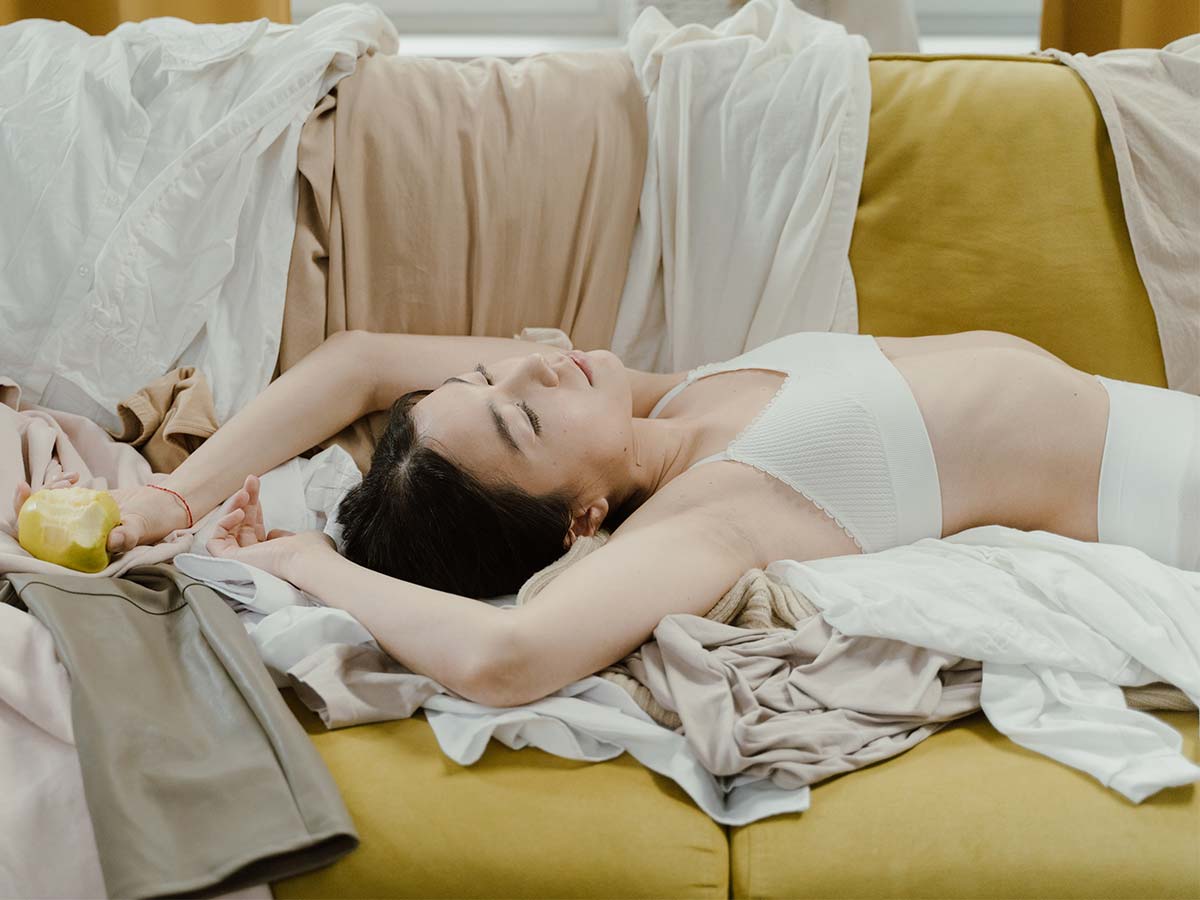 Mulher deitada no sofá vestindo lingerie com tons de nude