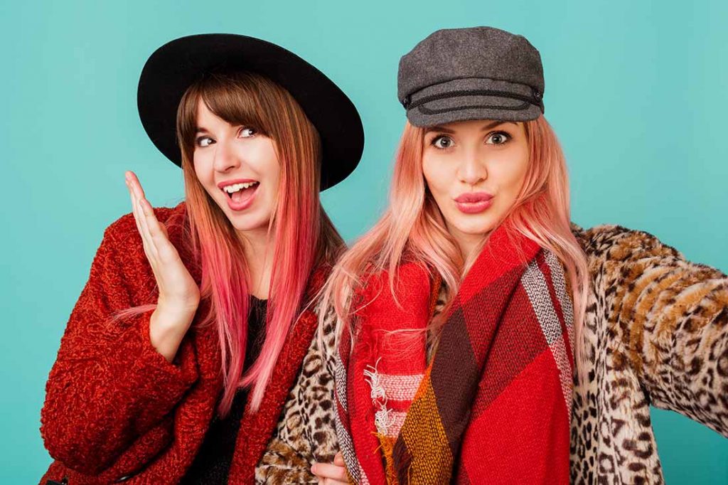 Duas jovens bonitas com looks no estilo preppy