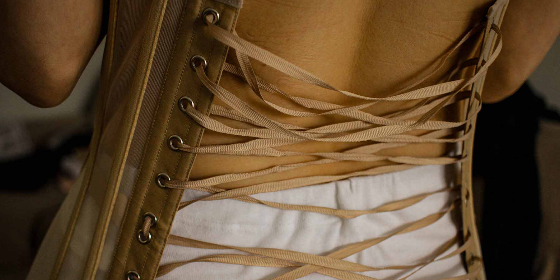 Mulher de costas mostrando a amarração do look com corset
