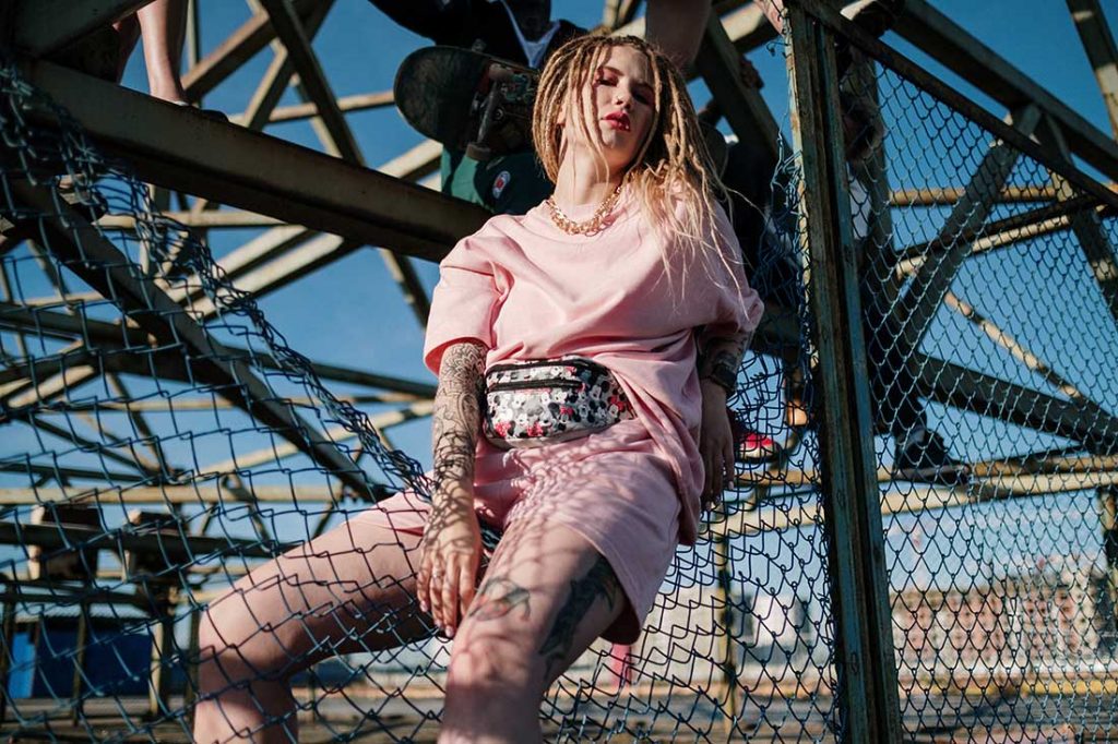 mulher loira com roupa rosa e dreadlocks
