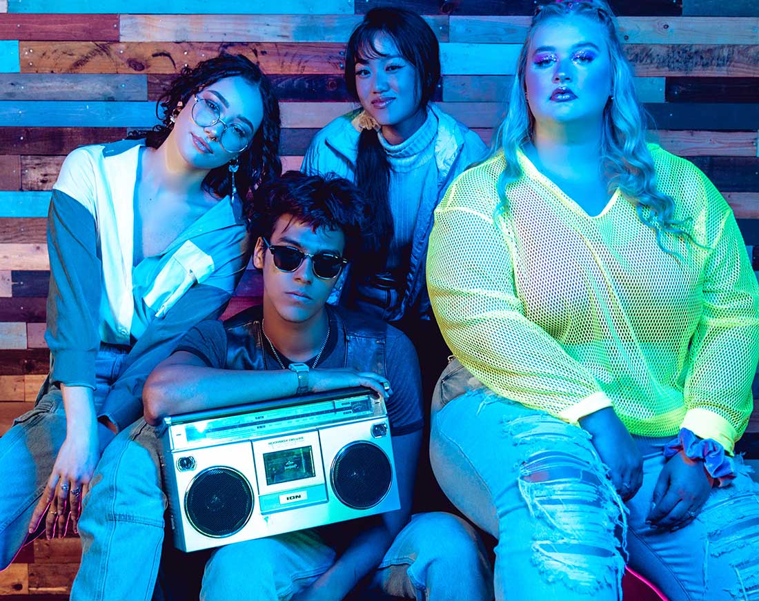 foto de quatro jovens, com roupas que remetem a estética da tendência anos 80