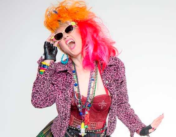 mulher com cabelo colorido, usando peças extravagantes típicas dos anos 80