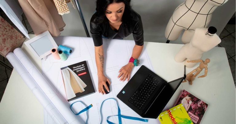 mulher designer de moda trabalhando em processos de modelagem digital em seu ateliê