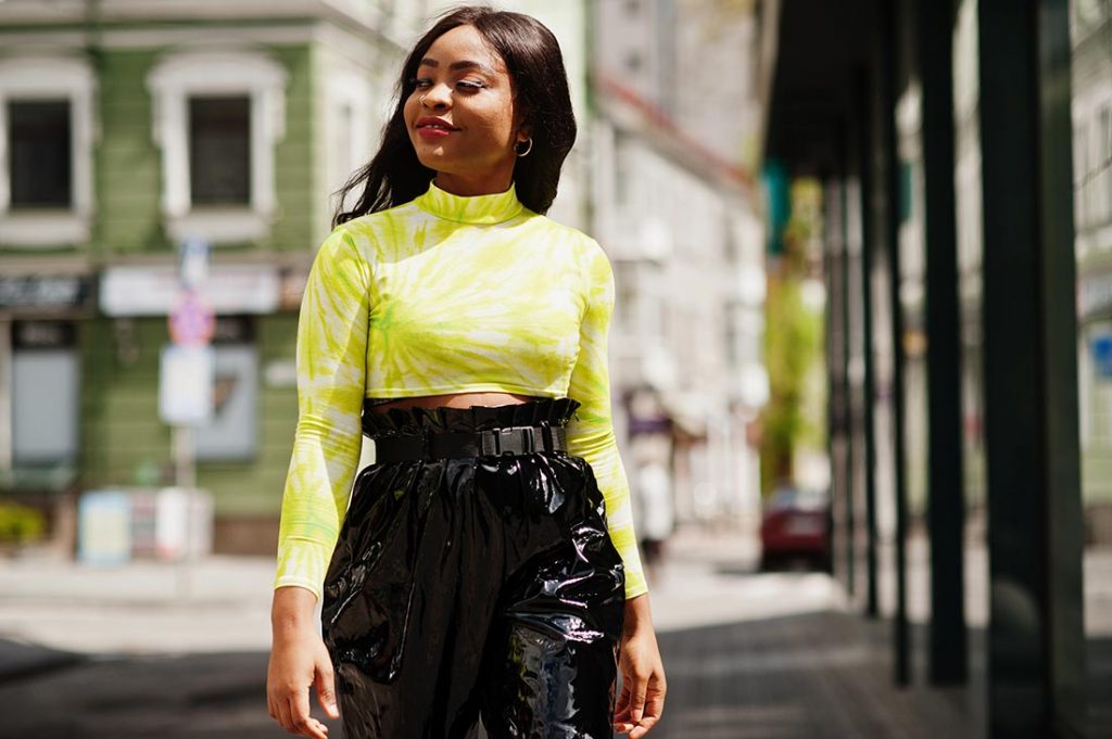 Jovem negra andando na rua dentro da moda para 2023