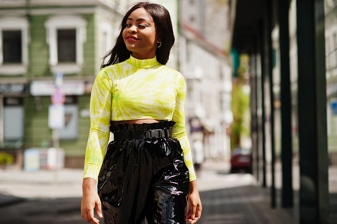 Jovem negra andando na rua dentro da moda para 2023